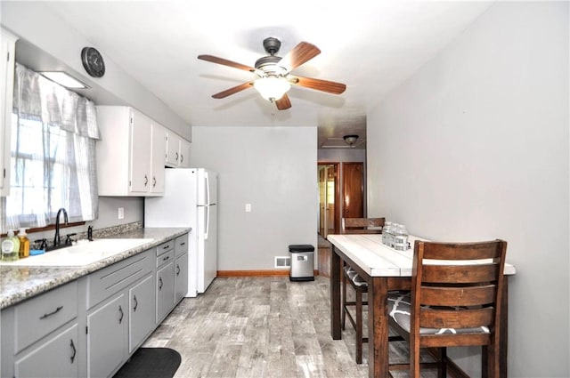 525 Joffre Bulger Rd, Smith, PA 15021 - kitchen with a sink, freestanding refrigerator, a ceiling fan, light wood-style flooring, and light countertops