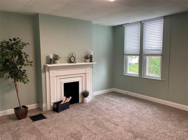 unfurnished living room with carpet floors, a fireplace, and baseboards