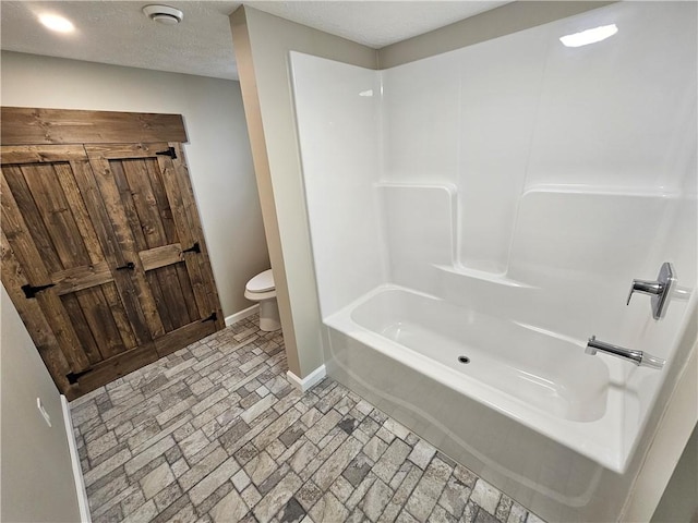 full bath featuring baseboards and toilet