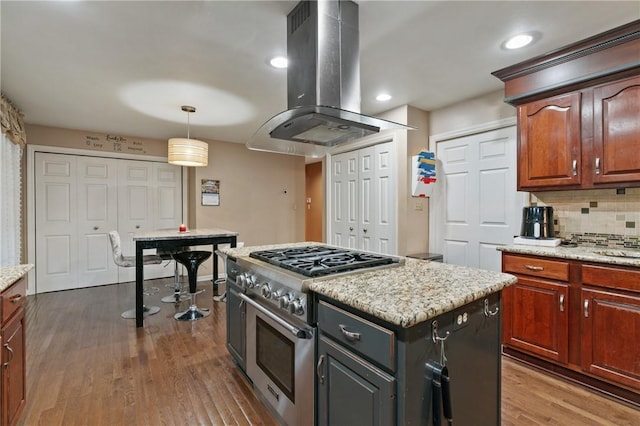 228 Meadowfield Ln, Jefferson Hills, PA 15025 - kitchen with stainless steel range, island range hood, dark wood-style floors, backsplash, and decorative light fixtures