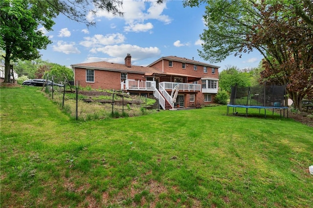 228 Meadowfield Ln, Jefferson Hills, PA 15025 - back of house with a trampoline, a wooden deck, a chimney, stairway, and a yard
