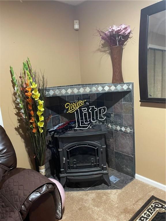 228 Meadowfield Ln, Jefferson Hills, PA 15025 - detailed view of a wood stove, carpet flooring, and baseboards