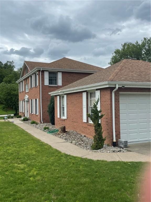 228 Meadowfield Ln, Jefferson Hills, PA 15025 - view of side of home featuring a garage, brick siding, a shingled roof, a lawn, and concrete driveway