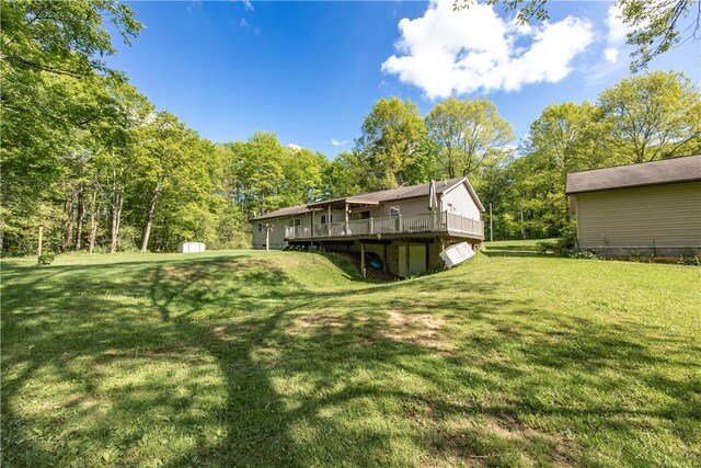 529 Mill Creek Rd, Mill Creek, PA 16362 - view of grassy yard featuring a deck, a storage unit, an outbuilding, and a wooded view