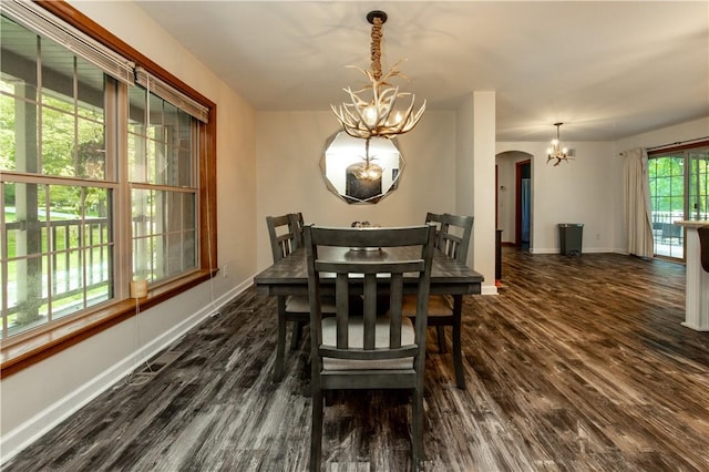 529 Mill Creek Rd, Mill Creek, PA 16362 - dining space featuring a chandelier, arched walkways, dark wood finished floors, and baseboards