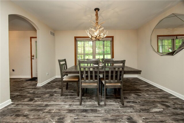 529 Mill Creek Rd, Mill Creek, PA 16362 - dining room featuring dark wood-style floors, baseboards, arched walkways, and a chandelier