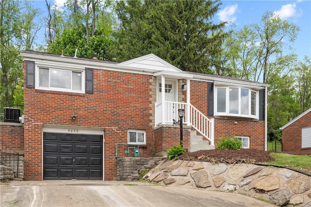 5056 Don St, Finleyville, PA 15332 - view of front of property featuring a garage, brick siding, concrete driveway, and central AC unit