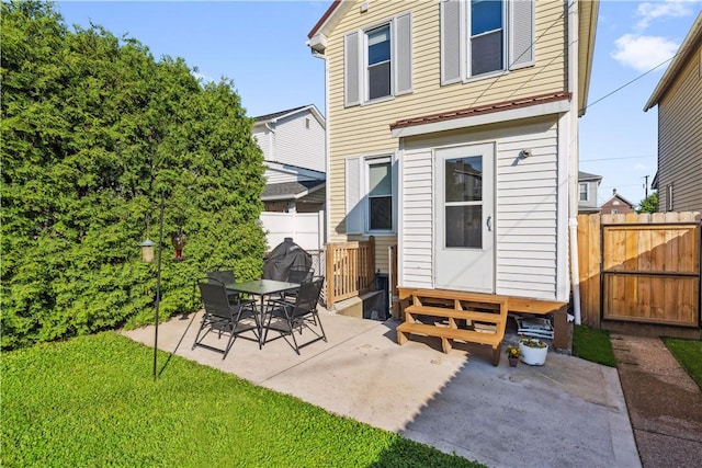 back of property featuring entry steps, a patio area, and a gate