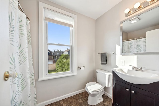 bathroom with baseboards, toilet, and vanity