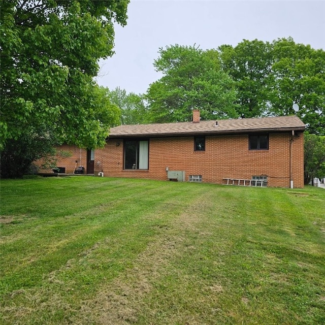 148 James St, Chippewa Twp, PA 15010 - back of property with brick siding, a yard, and a chimney