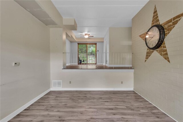 unfurnished dining area with wood finished floors, ceiling fan, and baseboards