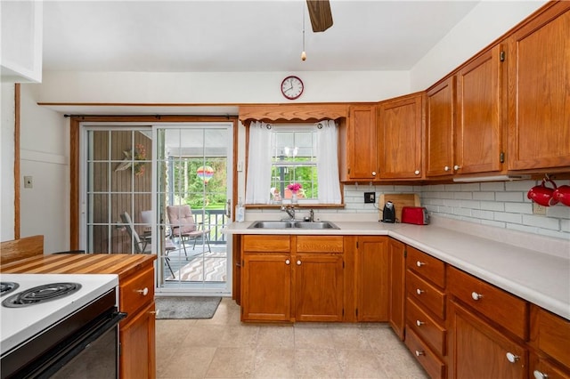 132 W Main St, Greenville Boro Mer, PA 16125 - kitchen featuring a sink, light countertops, tasteful backsplash, brown cabinetry, and range with electric cooktop