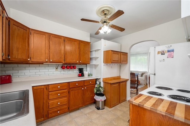 132 W Main St, Greenville Boro Mer, PA 16125 - kitchen with freestanding refrigerator, ceiling fan, backsplash, and brown cabinets