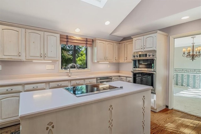 2652 Thorntree Dr, Upper St Clair, PA 15241 - kitchen with black electric stovetop, stainless steel double oven, a sink, light wood-style flooring, and light countertops