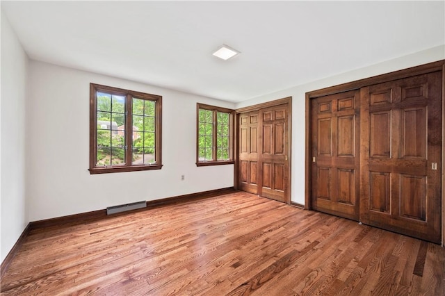 677 Harrogate Rd, Upper St Clair, PA 15241 - unfurnished bedroom with two closets, light wood-style floors, and baseboards