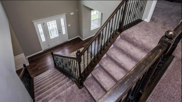 foyer featuring stairs, baseboards, and wood finished floors