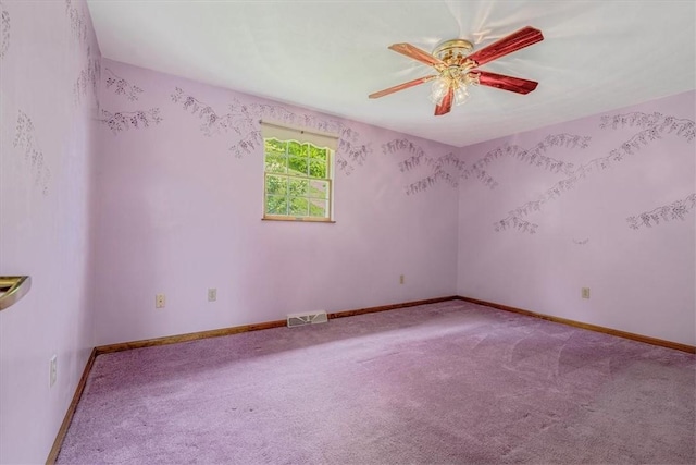carpeted empty room with ceiling fan and baseboards