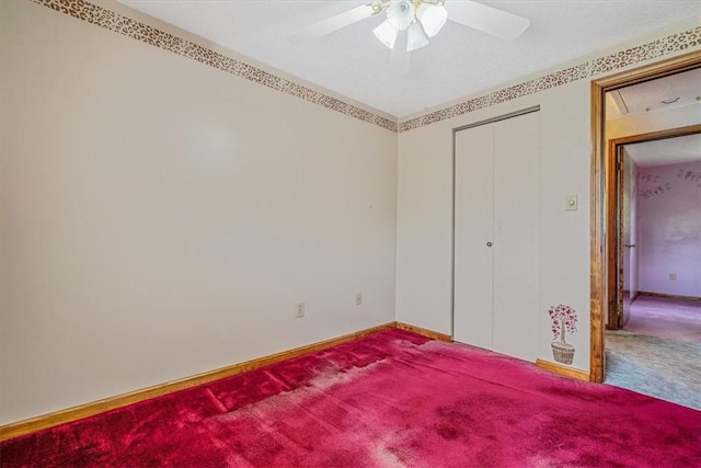 unfurnished bedroom with carpet, baseboards, a ceiling fan, and a closet