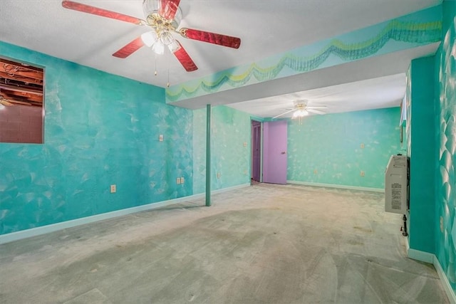 carpeted spare room with ceiling fan and baseboards