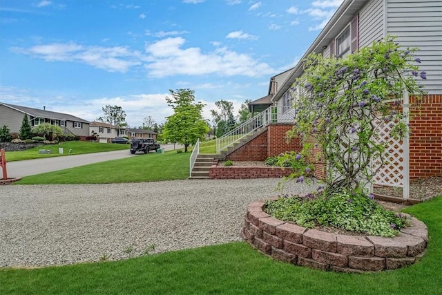 view of grassy yard featuring stairway and a residential view