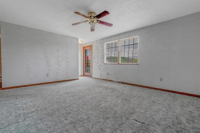 unfurnished room with a ceiling fan, carpet floors, baseboards, and a textured ceiling