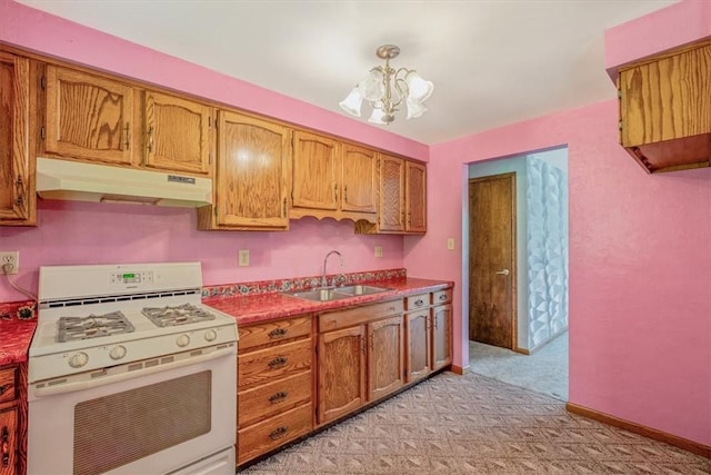 kitchen with under cabinet range hood, white range with gas stovetop, a chandelier, light carpet, and a sink
