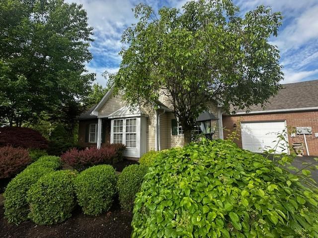 view of front of house featuring a garage and brick siding