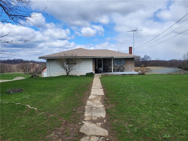 back of house with a lawn and a patio area