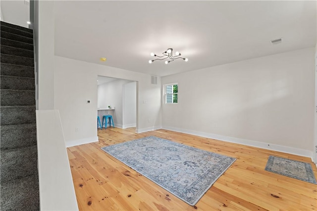 23 Saint Thomas St, South Side, PA 15203 - unfurnished living room featuring stairway, light wood-style flooring, baseboards, and a chandelier