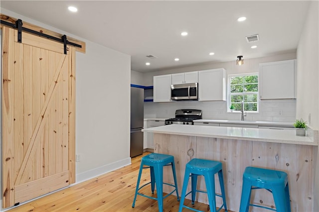 23 Saint Thomas St, South Side, PA 15203 - kitchen with appliances with stainless steel finishes, a kitchen bar, tasteful backsplash, light countertops, and recessed lighting