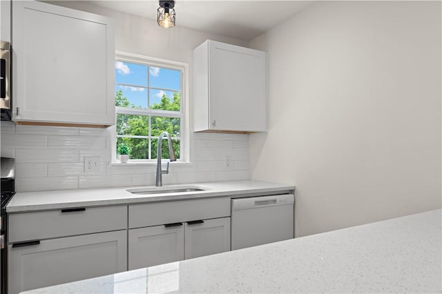 23 Saint Thomas St, South Side, PA 15203 - kitchen featuring white dishwasher, a sink, backsplash, white cabinets, and light stone counters