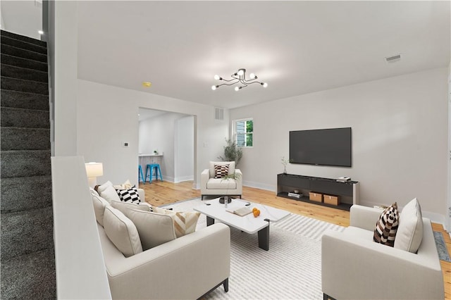 23 Saint Thomas St, South Side, PA 15203 - living room with stairway, wood finished floors, a chandelier, and baseboards