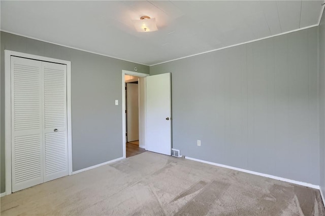 unfurnished bedroom featuring carpet flooring, baseboards, and a closet