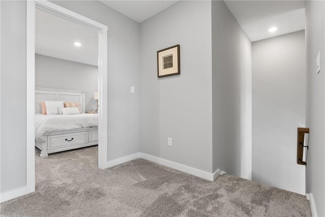 corridor featuring carpet floors, baseboards, and recessed lighting