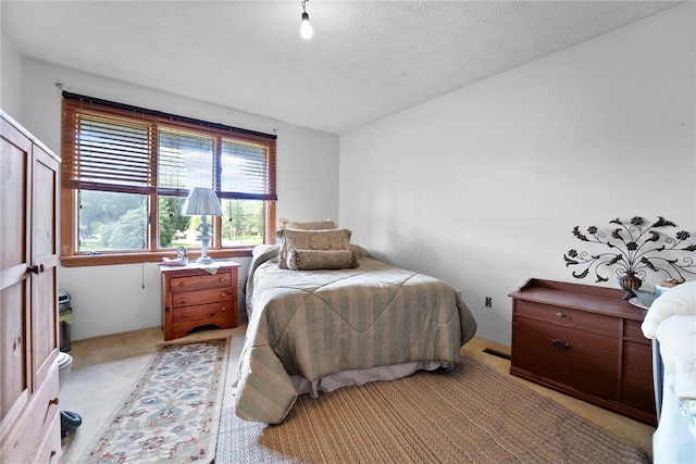 bedroom featuring light carpet and a textured ceiling