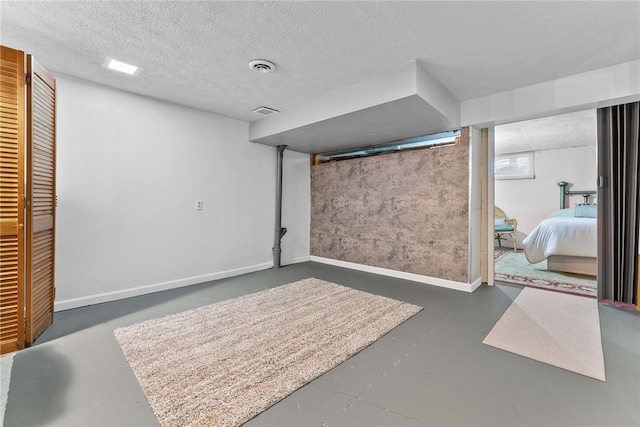 below grade area with baseboards and a textured ceiling