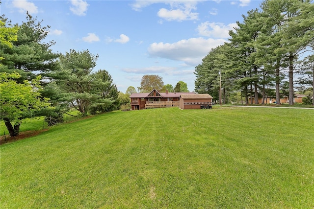 view of grassy yard with a wooden deck