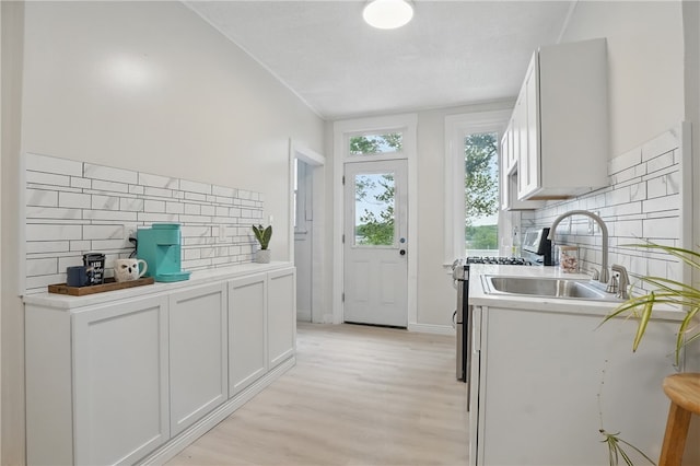 3316 Alberta St, Munhall, PA 15120 - kitchen with a sink, stainless steel range with gas cooktop, backsplash, light wood-type flooring, and white cabinetry
