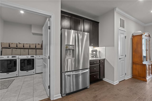 kitchen featuring stainless steel fridge, independent washer and dryer, ornamental molding, baseboards, and light wood-style flooring