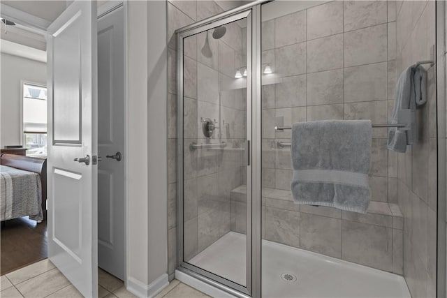 full bathroom with a stall shower, ensuite bathroom, tile patterned floors, and baseboards
