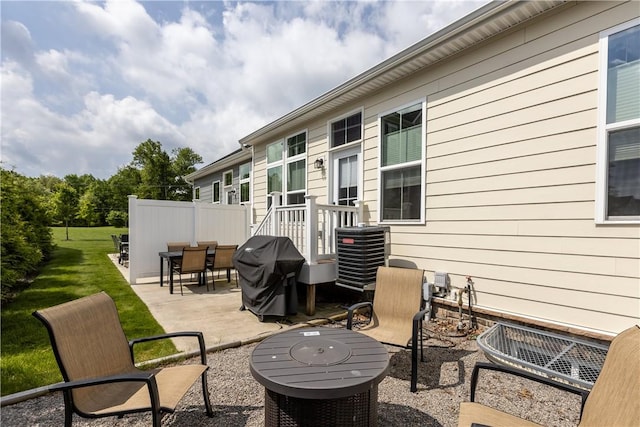 view of patio with outdoor dining area, cooling unit, and a grill