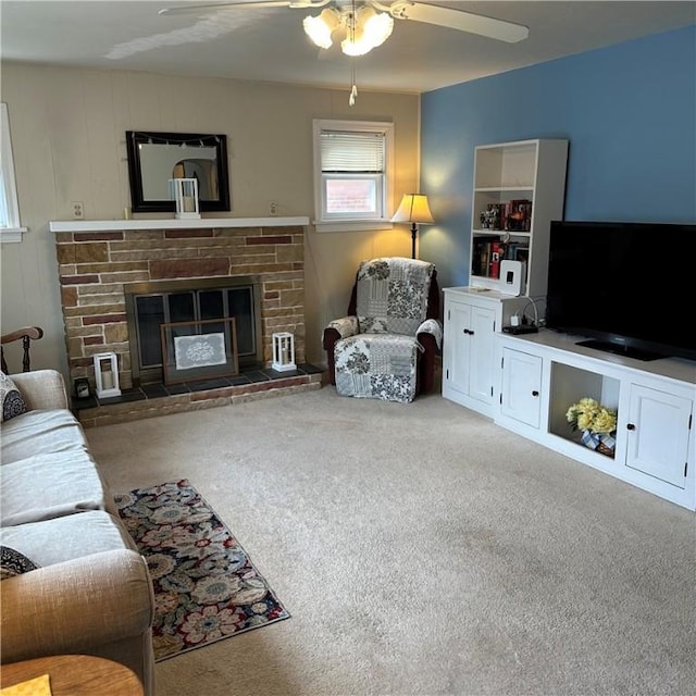 carpeted living area featuring ceiling fan and a glass covered fireplace