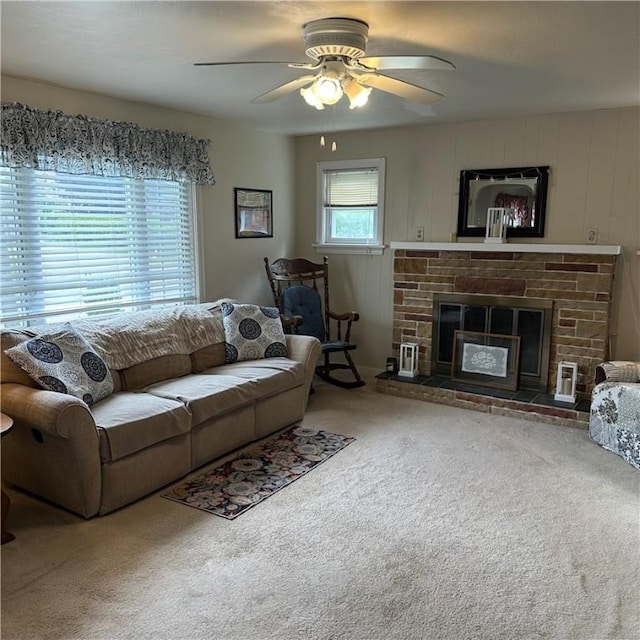 carpeted living area with a ceiling fan and a fireplace