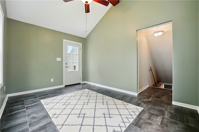 entrance foyer featuring a ceiling fan, baseboards, and high vaulted ceiling