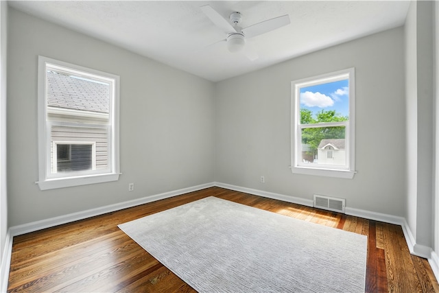 spare room with baseboards, a ceiling fan, and dark wood-style floors