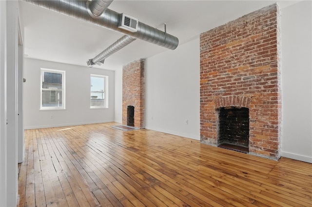 5111 Penn Ave, Garfield, PA 15224 - unfurnished living room featuring a fireplace, hardwood / wood-style floors, and baseboards