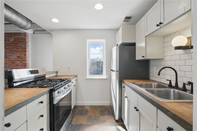 5111 Penn Ave, Garfield, PA 15224 - kitchen with stainless steel appliances, a sink, baseboards, tasteful backsplash, and white cabinetry