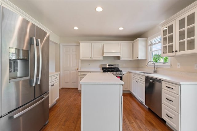 kitchen with appliances with stainless steel finishes, a sink, a center island, white cabinets, and recessed lighting