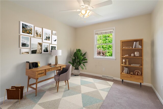 home office with a ceiling fan, baseboards, and light colored carpet