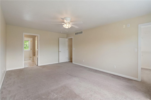 unfurnished bedroom featuring a spacious closet, carpet, baseboards, and connected bathroom